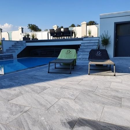 Überlaufpool und Naturstein-Pflaster Rauberger